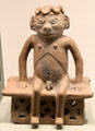 Carchi earthenware seated male figure on bench from Ecuador at Gardiner Museum. Toronto, ON.