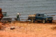 Loading seaweed onto pickup trucks in the surf. PE.