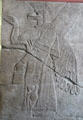One of pair of Assyrian reliefs of libation induced transition between winged human body with bird head to more normal form with panel over inscribed with cuneiform text at Pergamon Museum. Berlin, Germany.