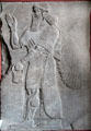 One of pair of Assyrian reliefs of libation induced transition between winged human body with bird head to more normal form with panel over inscribed with cuneiform text at Pergamon Museum. Berlin, Germany.