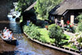Canal cruising behind houses. Giethoorn, Netherlands.