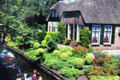 Lush gardens beside the river. Giethoorn, Netherlands