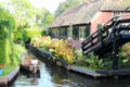 Narrow side canal with boat used for transportation around the town. Giethoorn, Netherlands