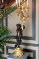 Statue holding gilded candelabra in stairwell. Het Loo, Netherlands.
