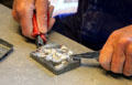 Artisan removing tin figure from mold at National Tin Figure Museum. Ommen, Netherlands.