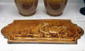 Earthenware tile with woman & animals of mustard glaze by Dunmore Pottery at Museum of Edinburgh. Edinburgh, Scotland.