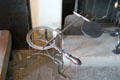 Metal trivet for kettle with attached roasting fork beside kitchen fireplace at Georgian House museum. Edinburgh, Scotland.