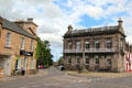 Little cross on Elgin High Street flanked by heritage buildings. Elgin, Scotland.