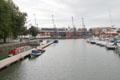 View of warehouses & cranes once used to receive goods from ships docking at Floating Harbour. Bristol, England.