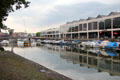 Boats moored on Floating Harbour in front of former warehouses, now re-purposed to shopping area, in the background. Bristol, England.