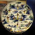 Ceramic dish decorated to resemble scenes from Chinese pottery, likely made Limekiln Lane Bristol at Bristol Museum & Art Gallery. Bristol, England.
