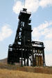 Mineshaft headframe stands atop rock face. Butte, MT.