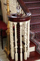 Front staircase newel post encircled by finely & variously carved rails at Eastman House. Rochester, NY.