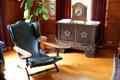 Reclining wing back armchair beside elaborate cabinet in billiard room at Eastman House. Rochester, NY.