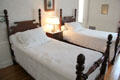 Bedroom with carved mahogany low post twin beds with pineapple finials at Eastman House. Rochester, NY.