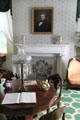 Pedestal center table with brass sinumbra lamp with glass shade & prisms in front of sitting room fireplace with wallpaper-covered fireboard at Lindenwald. Kinderhook, NY.
