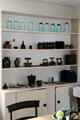 Kitchen shelving with glass canning jars, molds, round bladed chopping knives & other utensils at Lindenwald. Kinderhook, NY.